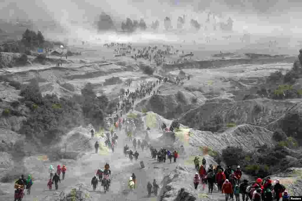 Tenggerese people and tourists gather near the Bromo volcano during the annual Kasada ceremony where Hindu worshipers have a ritual with throwing offerings such crops and livestock into the crater as thanks giving to their gods, in Probolinggo, East Java, Indonesia.