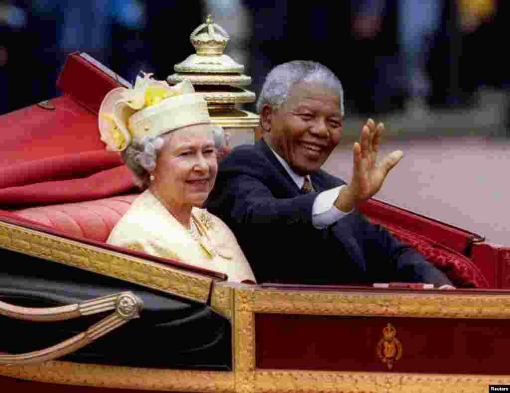 South African President Nelson Mandela is accompanied by Britain's Queen Elizabeth II in a carriage ride to a Buckingham Palace lunch on the first day of his state visit to Britain, July 9, 1996.
