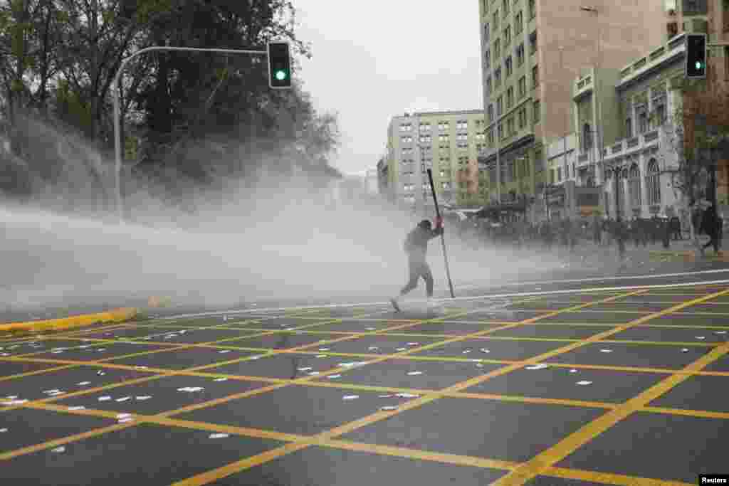 A jet of water is released on demonstrators during a protest marking the 49th anniversary of the 1973 Chilean military coup, in Santiago, Chile.