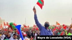 Comício da UNITA - Um homem ergue uma pequena bandeira do partido no meio da multidão. Cazenga, Luanda, Angola