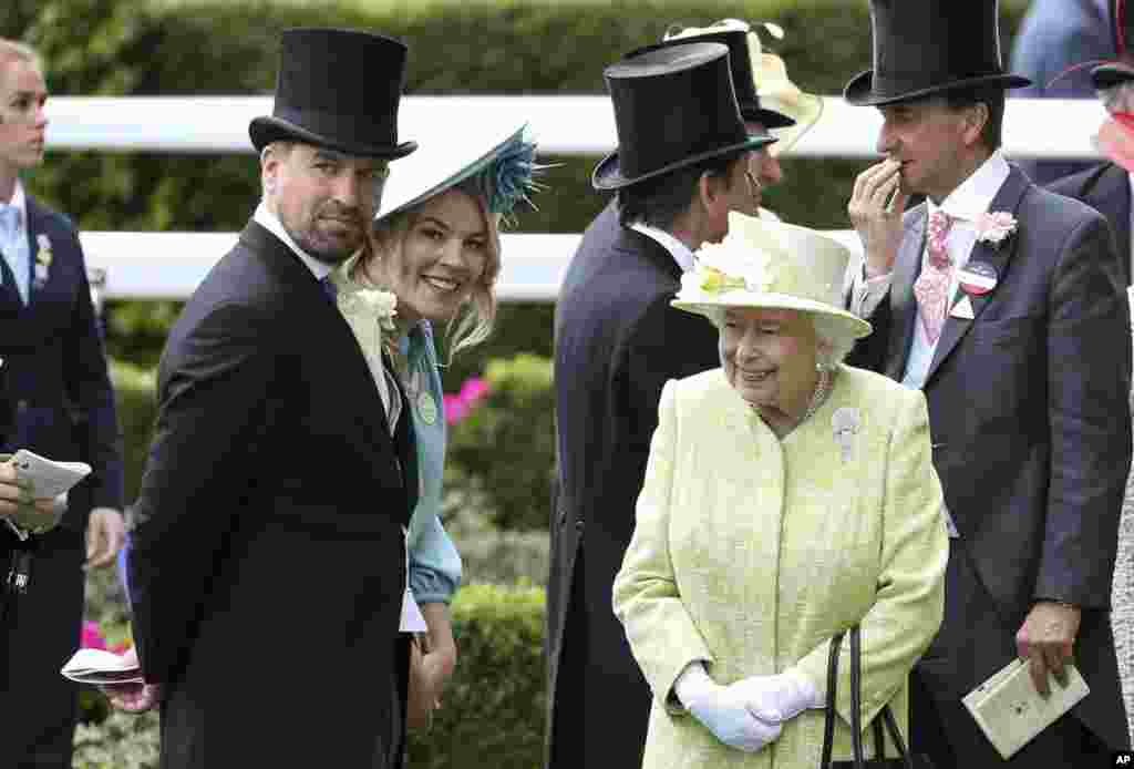 Britain's Queen Elizabeth II right talks to her grandson, Peter Phillips, left and his wife Autumn, during day five of Royal Ascot in Ascot, England, June 22, 2019.