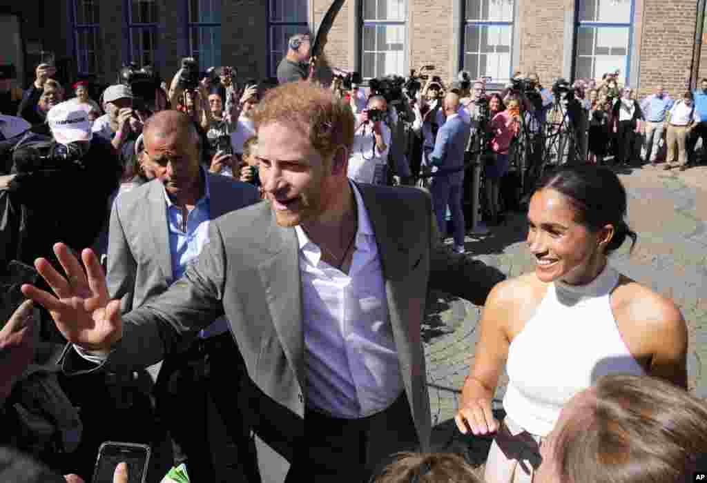 Britain's Prince Harry, left, and Meghan, Duchess of Sussex, meet people after a visit at the town hall in Duesseldorf, Germany. Prince Harry visits the city as ambassador for the Invictus games, a week-long games for active servicemen and veterans who are ill, injured or wounded, hosted by Duesseldorf next year.