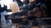 FILE - Palestinians line up for a meal in Rafah, Gaza Strip, Feb. 16, 2024. The World Food Program said Tuesday it has paused deliveries of food to isolated northern Gaza because of chaos across the territory, hiking fears of potential starvation.