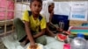 A Rohingya refugee child eats at Balukhali refugee camp, Cox’s Bazar, March 13, 2023. His grandmother eats watermelon.
