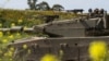 FILE - Israeli soldiers move on the top of a tank near the Israeli-Gaza border, as seen from southern Israel, March 21, 2024. U.S. weapons sales to Israel are under increased scrutiny amid outrage over the deaths of more than 33,000 people in Gaza.