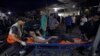 A wounded Palestinian is carried into the al-Shifa hospital following Israeli airstrikes on Gaza City, Oct. 26, 2023.
