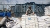 A worker rests as displaced Palestinians receive food aid at the United Nations Relief and Works Agency for Palestine Refugees (UNRWA) center in Rafah in the southern Gaza Strip on Jan. 28, 2024.