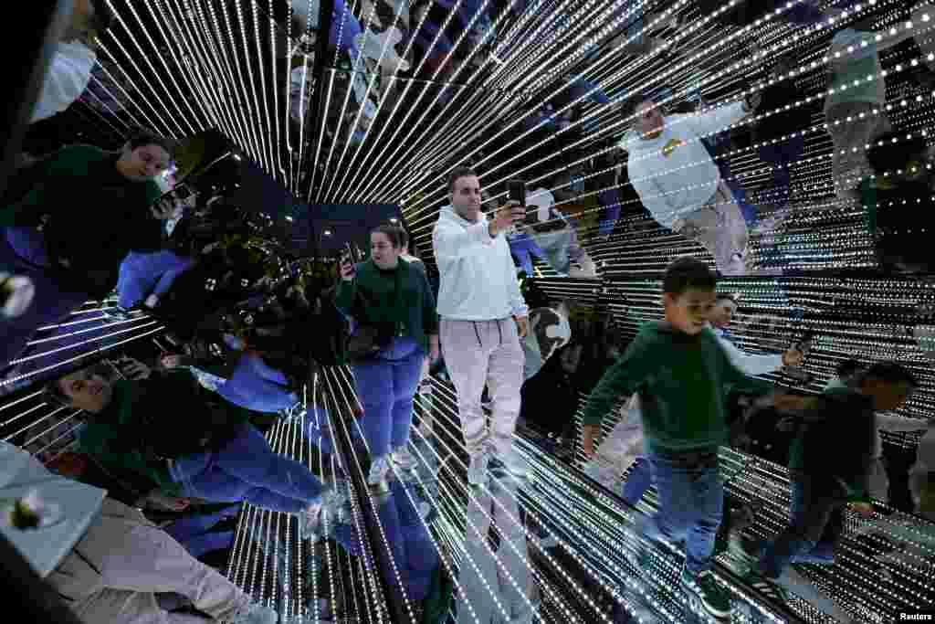 People walk through Passengers by Tetro+A & Yam during The White Night (in Basque, Gau Zuria) commemorating the founding of the Villa of Bilbao with light shows, music, art and literature at venues throughout the city in Bilbao, Spain, June 15, 2024.