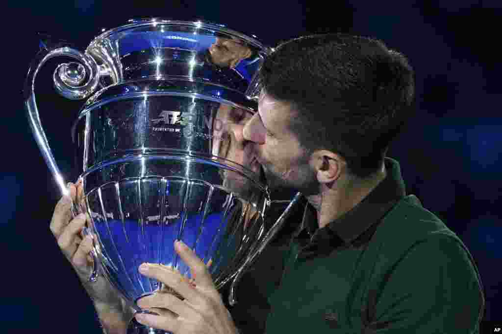 Serbia's Novak Djokovic kisses the trophy as ATP world best player at the ATP World Tour Finals, at the Pala Alpitour, in Turin, Italy.