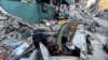 A Palestinian woman prepares a meal amid the rubble of her home, which was destroyed during Israel's military offensive, in Beit Lahia, northern Gaza Strip, March 13, 2024.