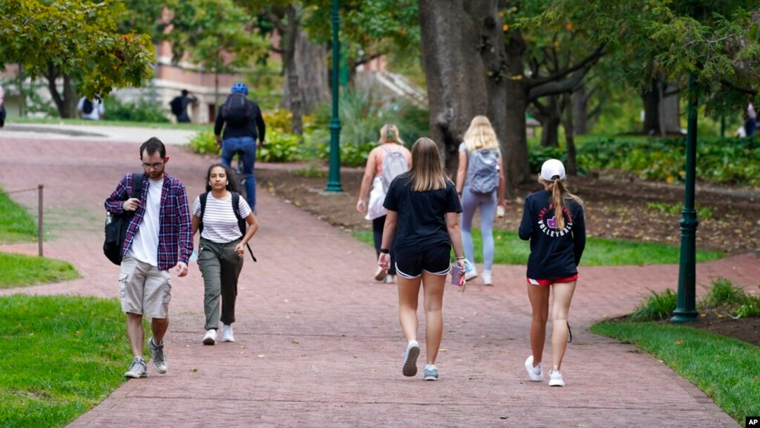 Students walk to and from classes on the Indiana University campus, Oct. 14, 2021, in Bloomington, Ind. 