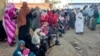 FILE - People displaced by the ongoing conflict in Sudan between the army and paramilitaries wait to receive aid from a charity in Gedaref, Sudan, Dec. 30, 2023. The United Nations warns that the people of Sudan are headed for crisis levels of food insecurity.