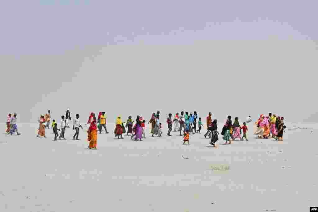 People travel towards a polling station to cast their ballot during the second phase of voting of India's general election at Gashbari village in Darrang district of Assam state.
