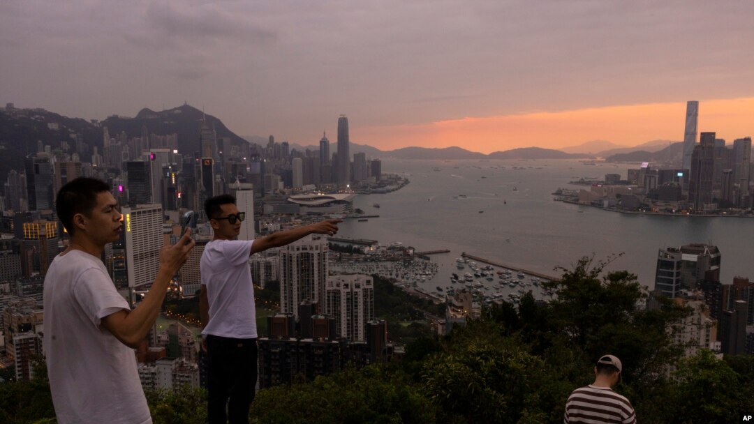 中國大陸游客在山頂拍攝香港夕照景色。(2023年4月26日)