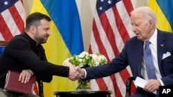 U.S. President Joe Biden shakes hands with Ukrainian President Volodymyr Zelenskyy in Paris, June 7, 2024.