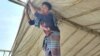 Mohammad Hussain’s shanty was gutted by fire March 5, 2023. Five days later, Islam is building a new shanty with the bamboo and tarpaulin he has got from the International Organization for Migration. (Noor Hossain/VOA)