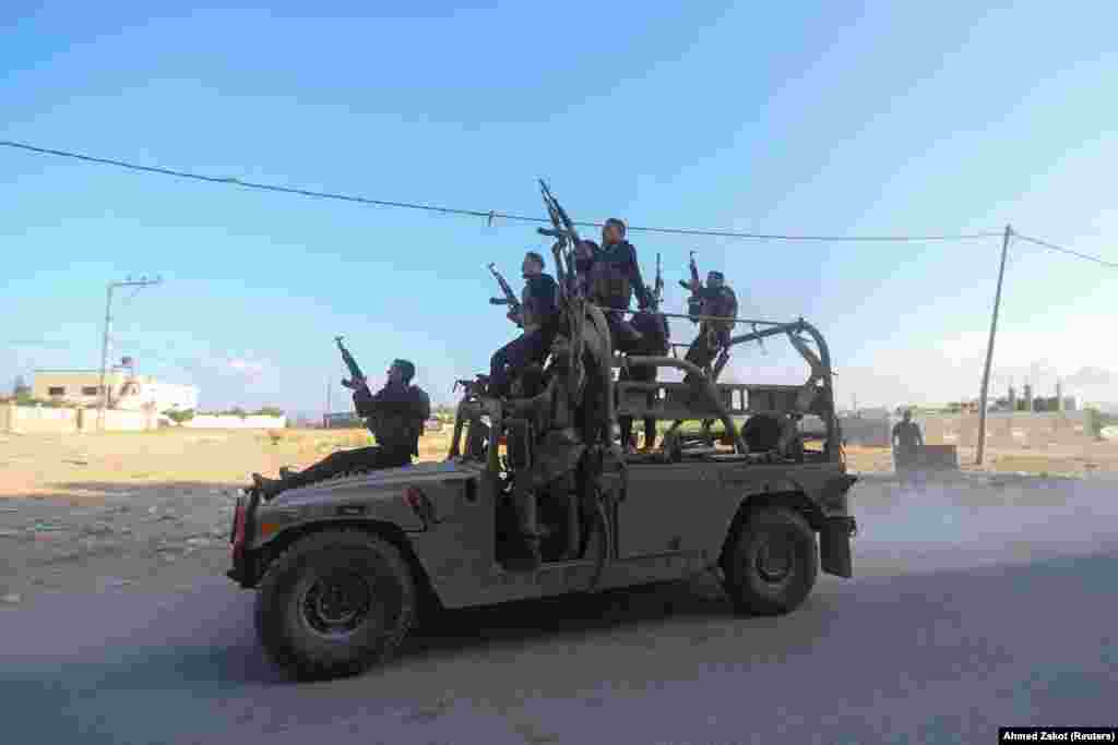 Palestinian militants ride an Israeli military vehicle that was seized by gunmen who infiltrated areas of southern Israel, in the northern Gaza Strip, Oct. 7, 2023. 