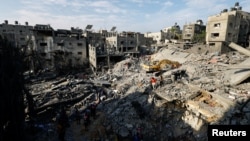 Emergency personnel work at the site of Israeli strikes on houses, as the conflict between Israel and Palestinian Islamist group Hamas continues, in Khan Younis in the southern Gaza Strip, Oct. 27, 2023.