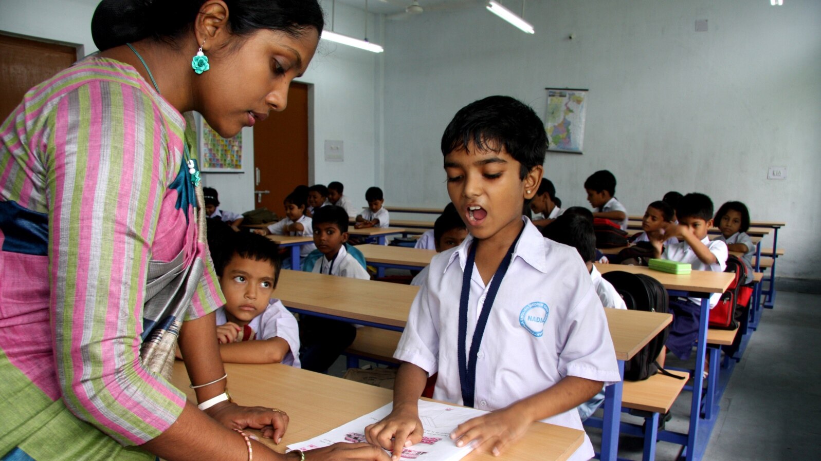 An instructor helps a student at an English modernized madrasa in West Bengal, India, April 2, 2024. (Shaikh Azizur Rahman/VOA)