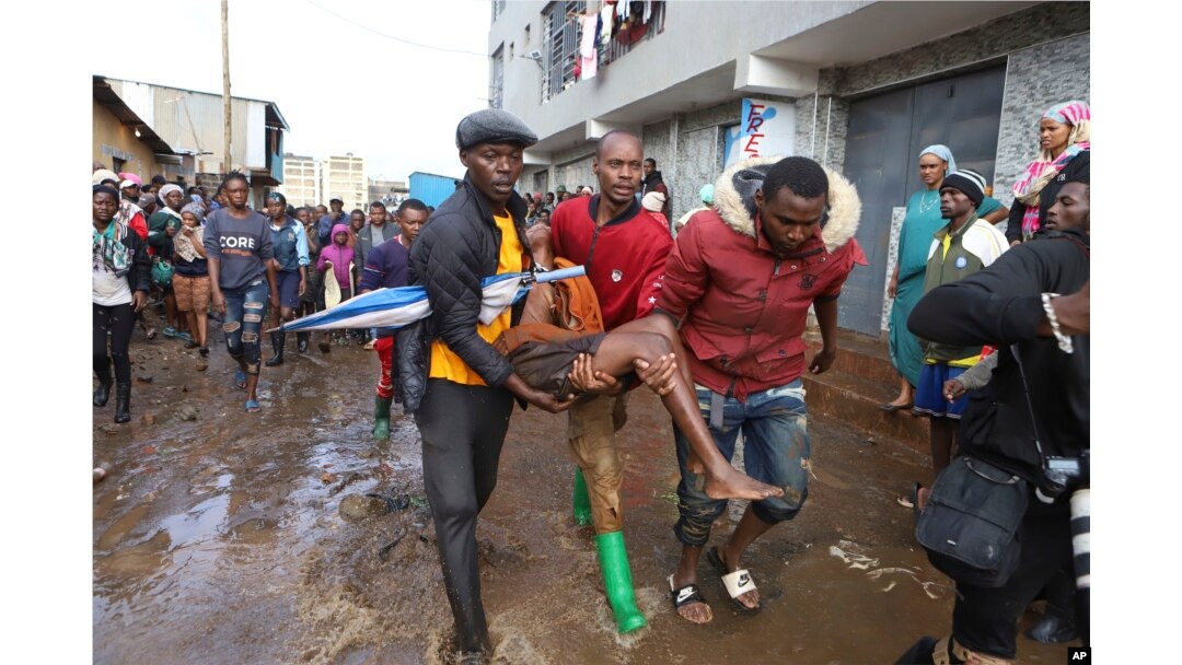 FILE - Residents rescue a woman who was caught during heavy rain in the Mathare area of Nairobi, Kenya, April 24, 2024. (AP Photo/Andrew Kasuku, File)