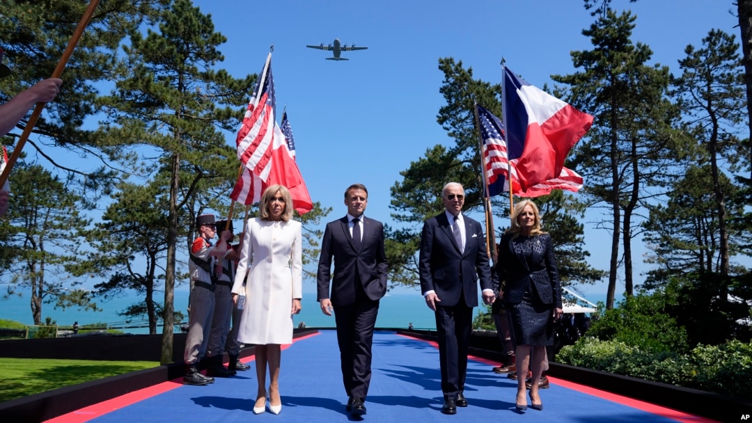 U.S. President Joe Biden walks with U.S. first lady Jill Biden, right, French President Emmanuel Macron, second from left, and his wife, Brigitte Macron, during ceremonies to mark the 80th anniversary of D-Day in Normandy, June 6, 2024. 