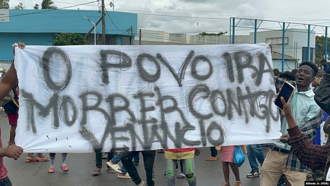 Manifestantes seguram um cartaz demonstrando o seu apoio a Venâncio Mondlane, que concorreu à liderança de Maputo