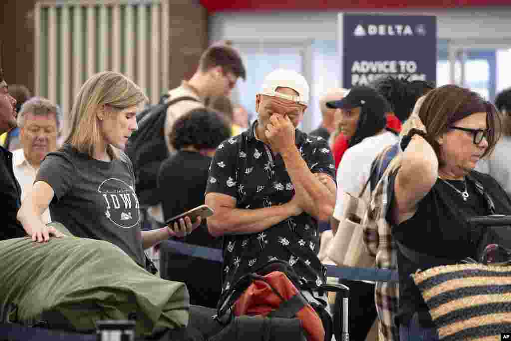 Passengers try to rebook their flights while at Hartsfield Jackson International Airport in Atlanta, as a major internet outage disrupts flights, banks, media outlets and companies across the world.