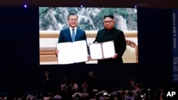 媒體在南韓首爾通過大屏幕觀看南韓前總統文在寅在平壤與北韓領導人金正恩簽署協議。(2018年9月19日）