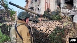 This image taken from footage posted May 25, 2023, on the Telegram account of the press service of Concord, a company linked to Wagner Group chief Yevgeny Prigozhin, shows Prigozhin talking to some of his fighters in Bakhmut.