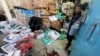A Palestinian worker stands next to boxes of aid stained with blood, at an UNRWA aid distribution center following an Israeli strike, as the conflict between Israel and Hamas continues, in Rafah, in the southern Gaza Strip, March 13, 2024.