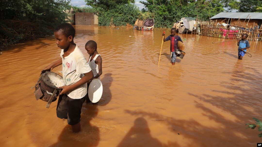 FILE - Children flee floodwaters that wreaked havoc at Mororo, border of Tana River and Garissa counties, Kenya, April 28, 2024. (AP Photo/Andrew Kasuku, File)