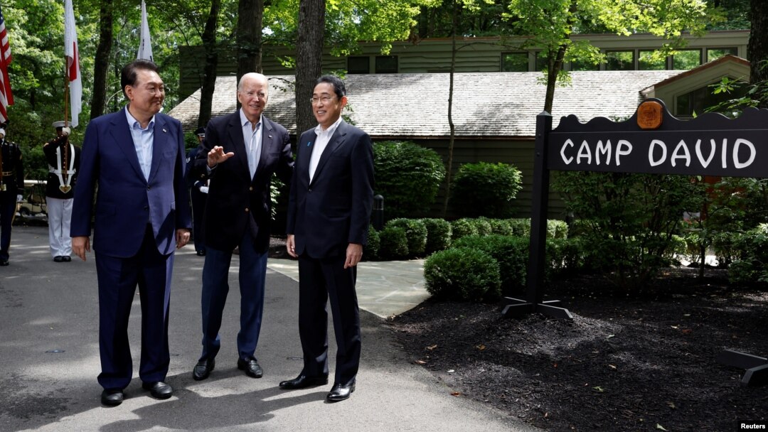 U.S. President Joe Biden greets Japanese Prime Minister Fumio Kishida, right, and South Korean President Yoon Suk Yeol during the trilateral summit Aug. 18, 2023, at Camp David near Thurmont, Md.