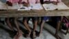 FILE - Students read books at a primary school on Ghoramara Island, India, Nov. 16, 2018. A teacher at a private elementary school in the state of Uttar Pradesh has come under fire for allegedly asking students to slap a Muslim classmate.