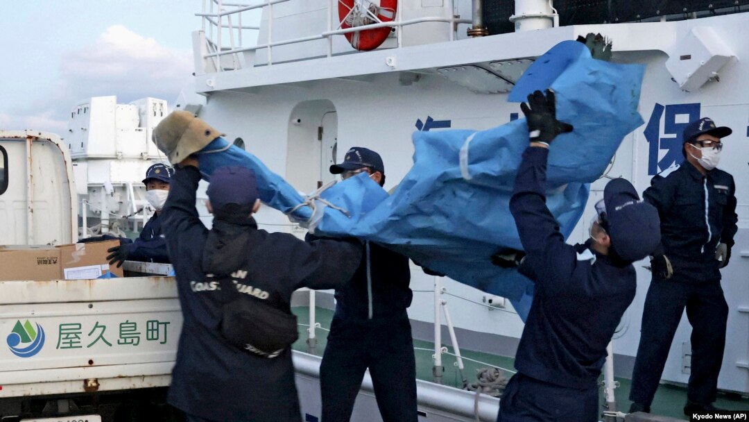 The members of Japanese Coast Guard carry the debris which are believed to be from the crashed U.S. military Osprey aircraft, at a port in Yakushima, Kagoshima prefecture, southern Japan, Dec. 4, 2023.