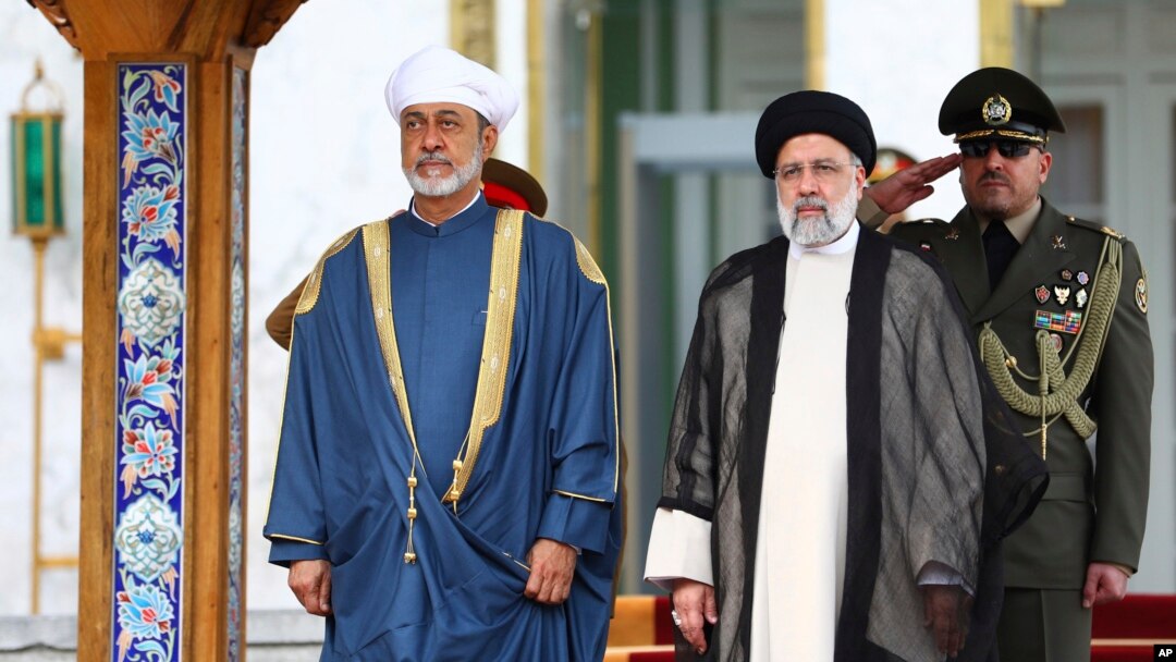 In this photo released by the office of the Iranian Presidency, Oman's Sultan Haitham bin Tariq Al Said, left, and Iranian President Ebrahim Raisi attend the official welcoming ceremony for Sultan Haitham at the Saadabad Palace in Tehran, May 28, 2023. 