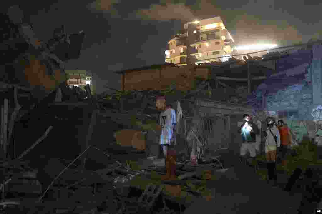 People look at the damage from a rocket fired from the Gaza Strip in Tel Aviv, Israel, Oct. 7, 2023.