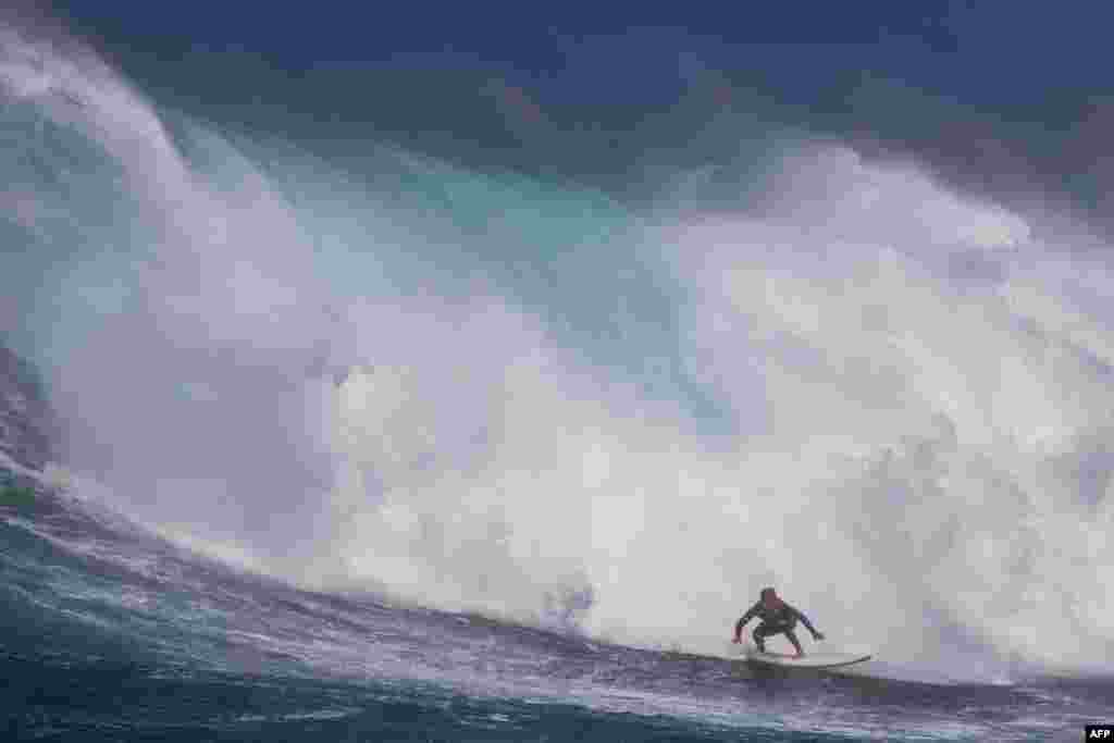 Hawaiian surfer Steve Roberson rides a wave as a big swell hits Pe'ahi surfing break, known as Jaws, on the north shore of the island of Maui, Hawaii, Oct. 17, 2023. (Photo by Brian Bielmann / AFP)