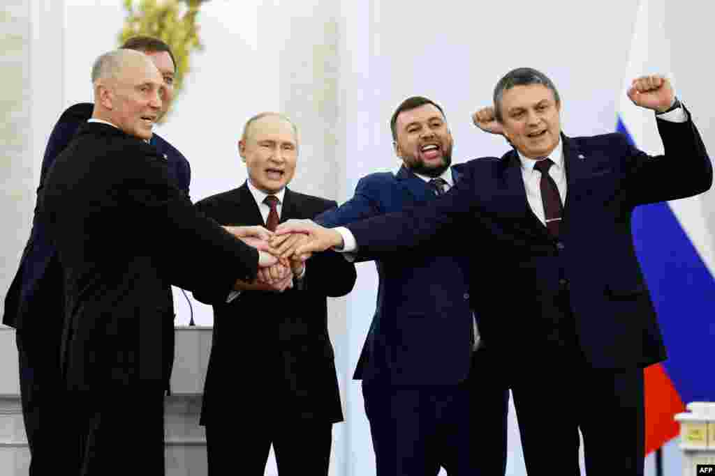 From left to right, the Moscow-appointed heads of Kherson region Vladimir Saldo and Zaporizhzhia region Yevgeny Balitsky, Russian President Vladimir Putin, Donetsk separatist leader Denis Pushilin and Lugansk separatist leader Leonid Pasechnik join hands after signing treaties formally annexing four regions of Ukraine occupied by Russian troops, at the Kremlin in Moscow. 