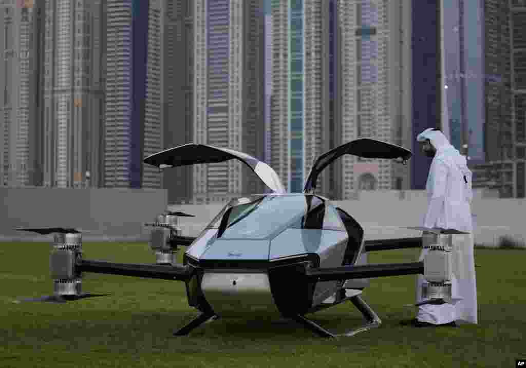 A man looks at the XPeng X2, an electric flying taxi developed by the Guangzhou-based XPeng, Inc's aviation affiliate, being tested in front of the Marina District in Dubai, United Arab Emirates.