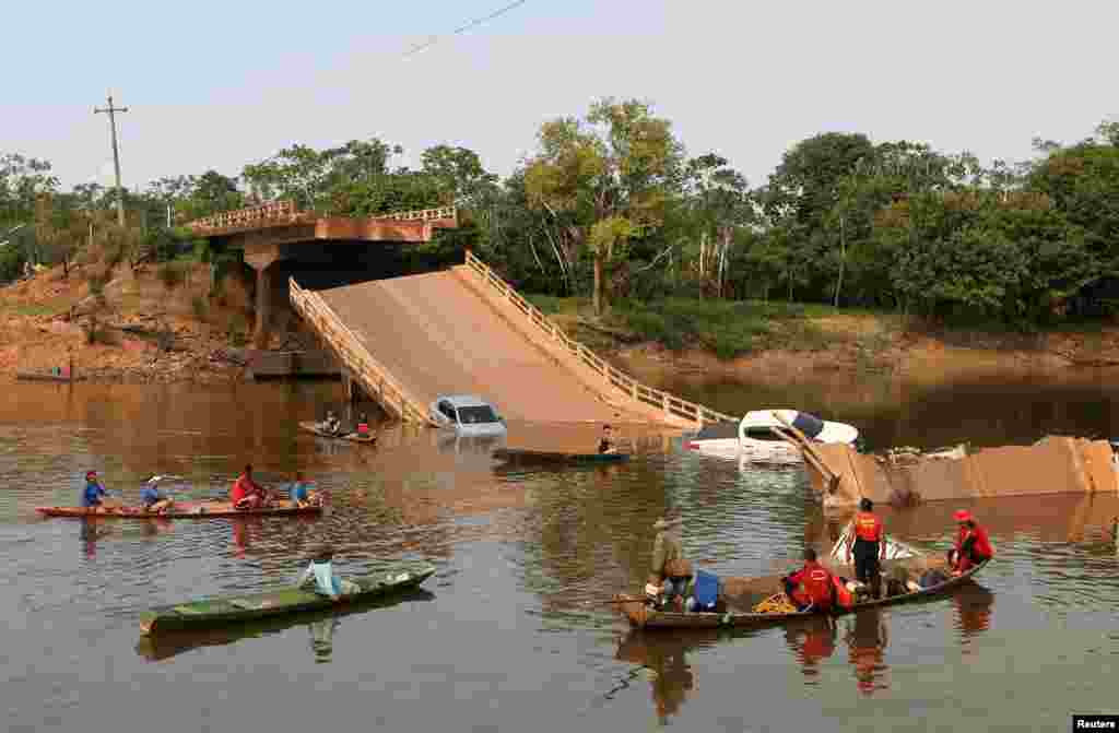 Locals and rescue workers navigate on boats at Curuca river after a bridge collapsed in BR-319 road in Careiro da Varzea, near Manaus, Brazil, Sept. 28, 2022.
