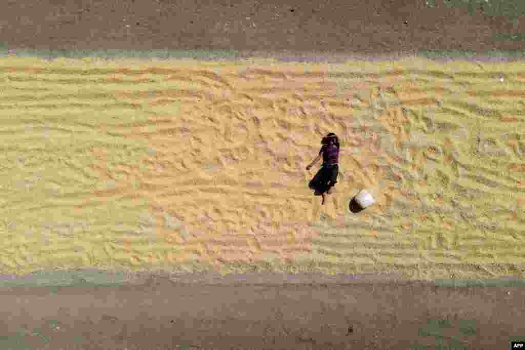 An aerial view shows a boy resting on drying corn near agricultural fields in the village of Jindayris in the Afrin region of Syria's rebel-held northern Aleppo province, Syria.