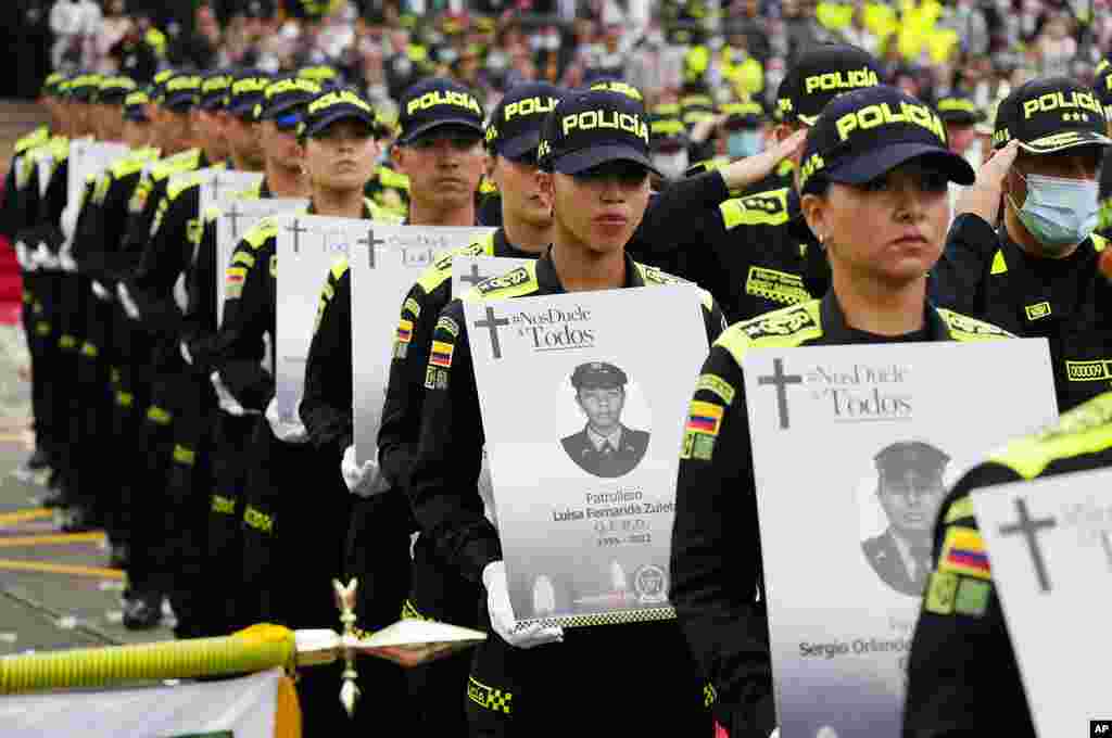 Colombian National Police hold photos of colleagues killed in the line of duty this year during a ceremony at the National Police Religious Center in Bogota, Colombia.
