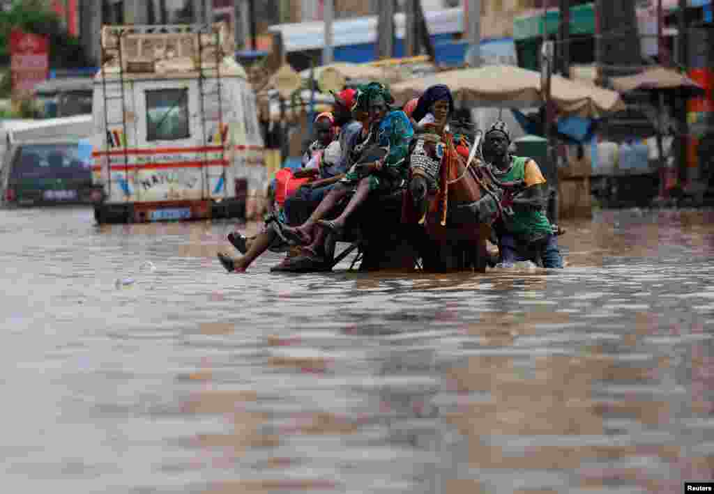 Residents make their way through a flooded street after heavy rains in the Yoff district of Dakar, Senegal, July 20, 2022.