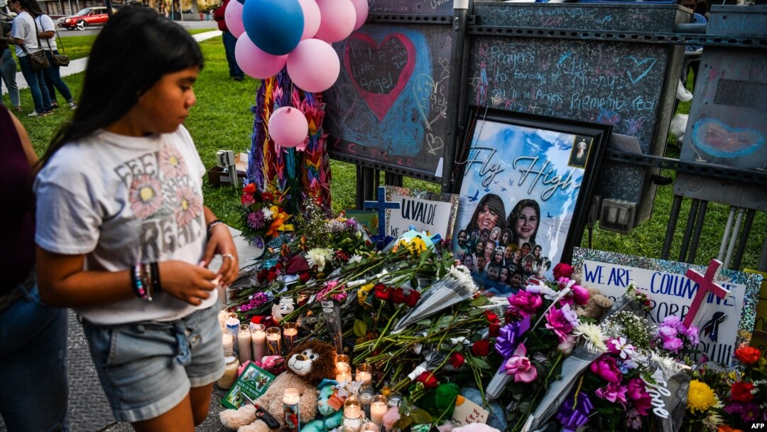 En esta foto de archivo tomada el 28 de mayo de 2022, una niña visita un monumento improvisado para las víctimas del tiroteo frente al juzgado del condado de Uvalde en Texas.