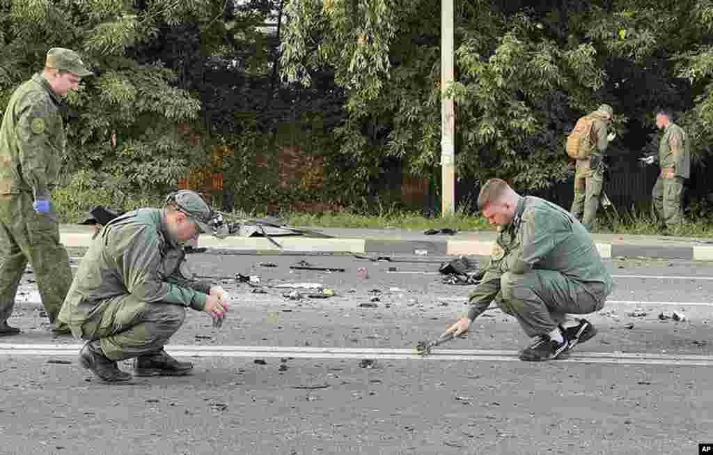 In this handout photo taken from video released by Investigative Committee of Russia, investigators work on the site of explosion of a car driven by Daria Dugina outside Moscow. Dugina, the daughter of Alexander Dugin, the Russian nationalist ideologist often called "Putin's brain", was killed when her car exploded on the outskirts of Moscow, officials said.