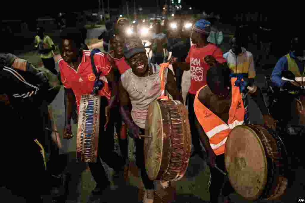 Supporters of Kenya presidential candidate Raila Odinga celebrate in the street ahead of the contested presidential election results in Kisumu, Kenya.