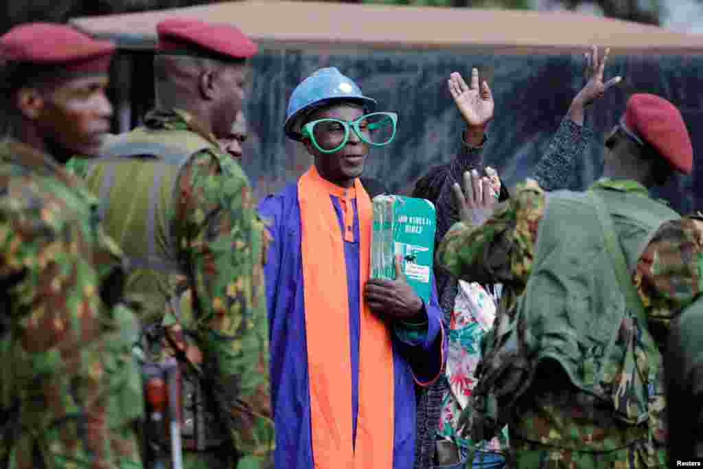 Police officers stand guard as supporters of Kenya's opposition leader and presidential candidate Raila Odinga of the Azimio La Umoja (Declaration of Unity) One Kenya Alliance, gather while his legal team prepares to file a petition challenging the presidential election result at the Supreme Court in Nairobi.