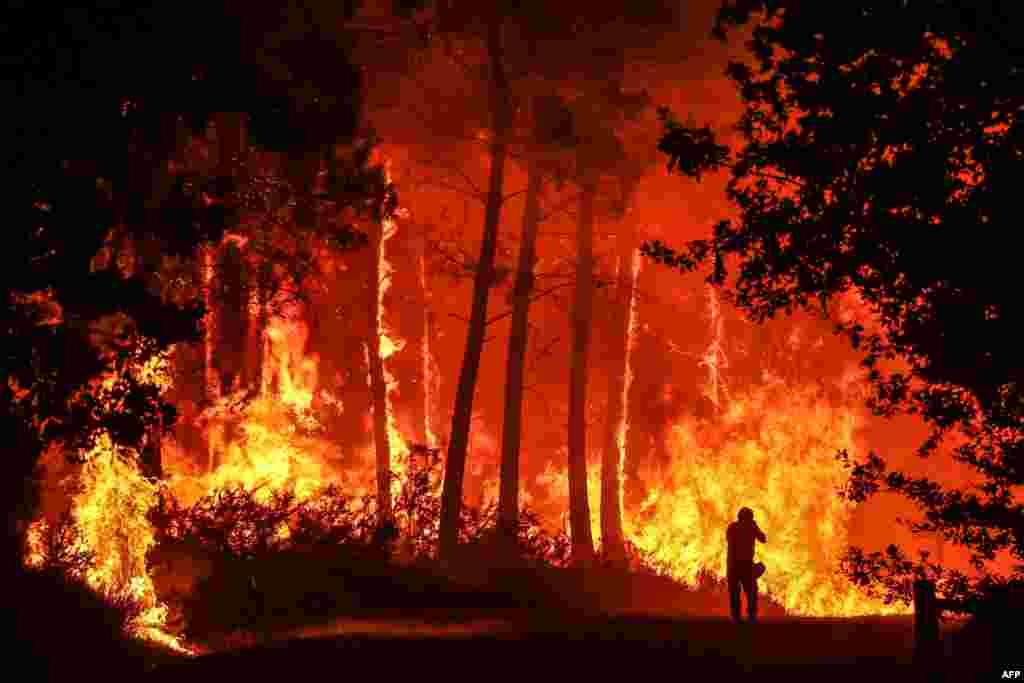 A wildfire burns near Belin-Beliet, France, and officials warned that flare-ups could cause the massive fire to spread in the country's parched southwest, where fresh blazes have already blackened swathes of land this week.