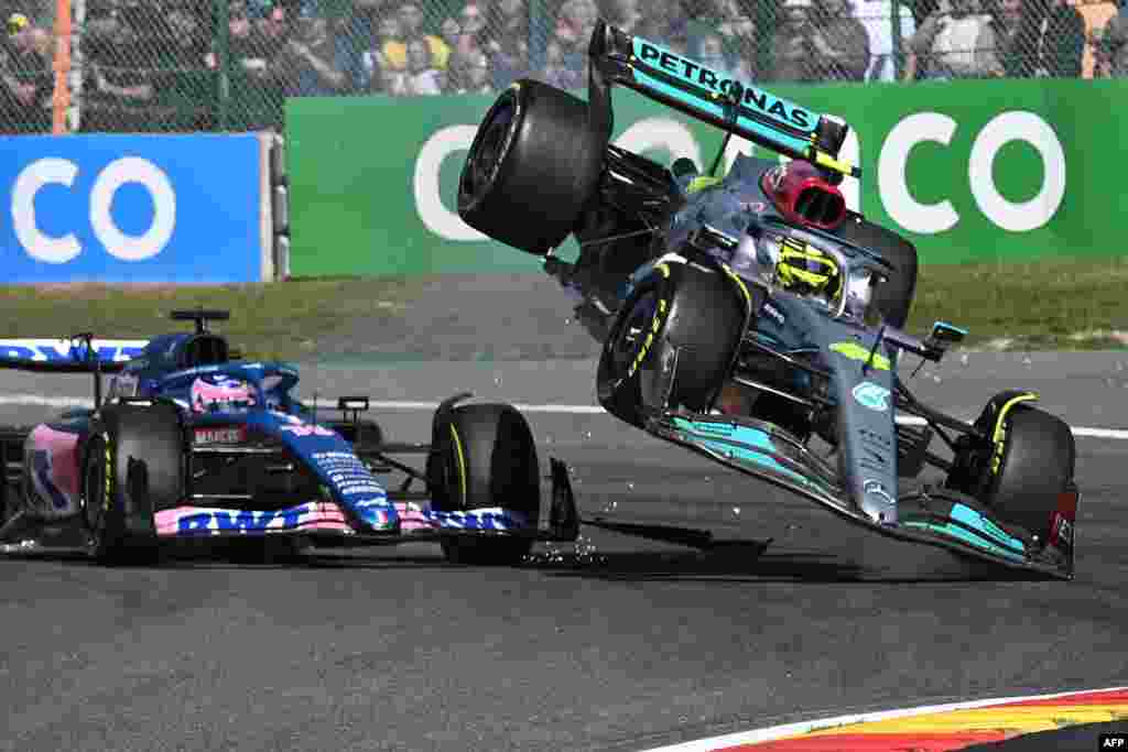 Mercedes' British driver Lewis Hamilton (R) collides with Alpine's Spanish driver Fernando Alonso (C) during the Belgian Formula One Grand Prix at Spa-Francophones racetrack at Spa, Belgium.