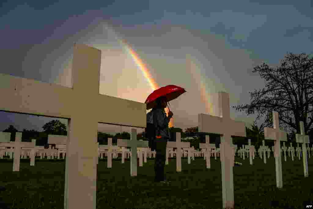 A man holding an umbrella looks for the grave of his relative at a cemetery for victims of World War II Ereveld Pandu, in Bandung, Indonesia, as part of the commemoration of the end of World War II in Southeast Asia 77 years ago.